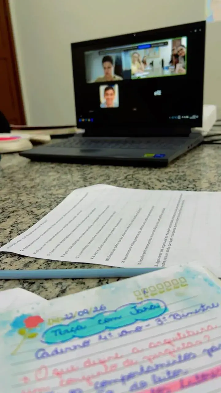 Consultoria entre visitas: caderno de registros aberto ao lado de uma reunião remota com a equipe da rede
